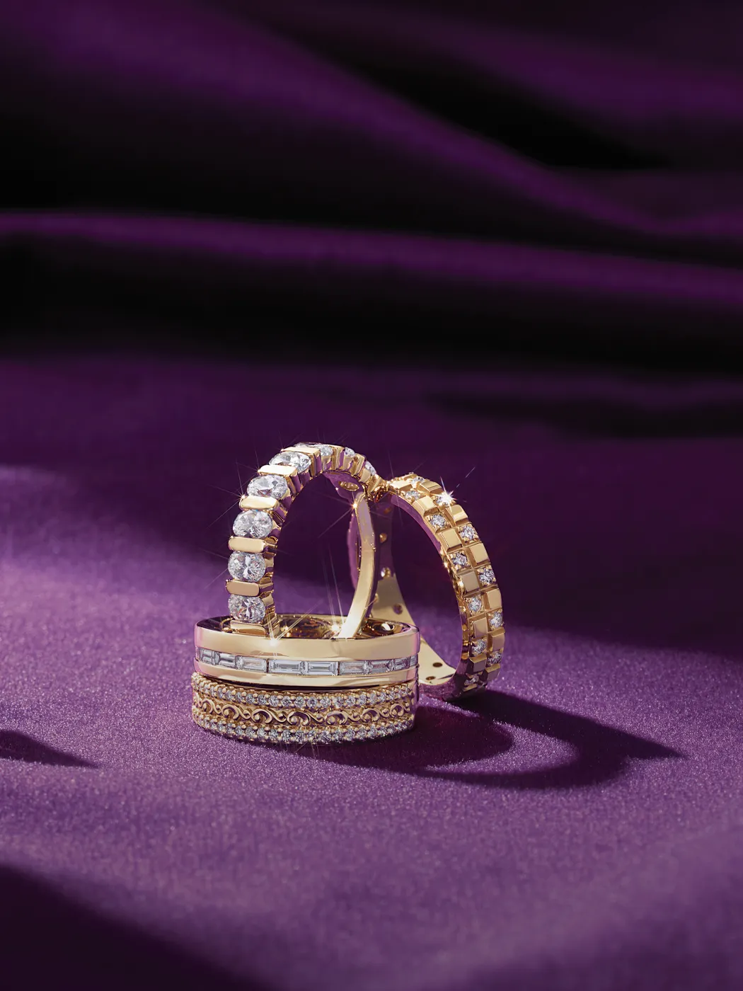 Diamond rings on purple fabric background, showcasing elegance and luxury.
