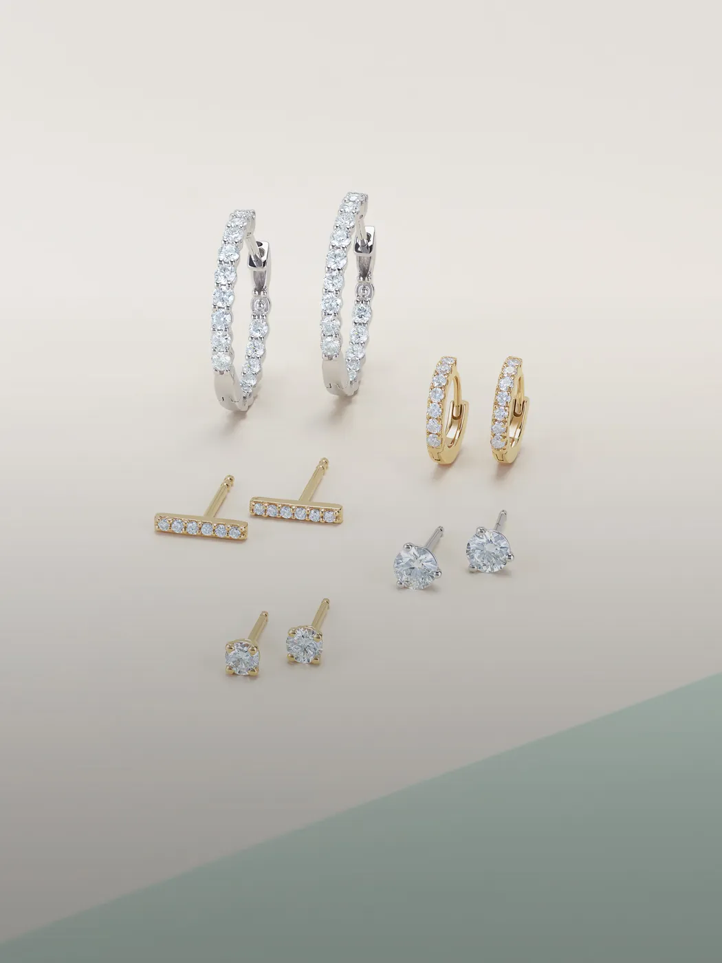 Diamond hoop and stud earrings in gold and silver on a gradient background.