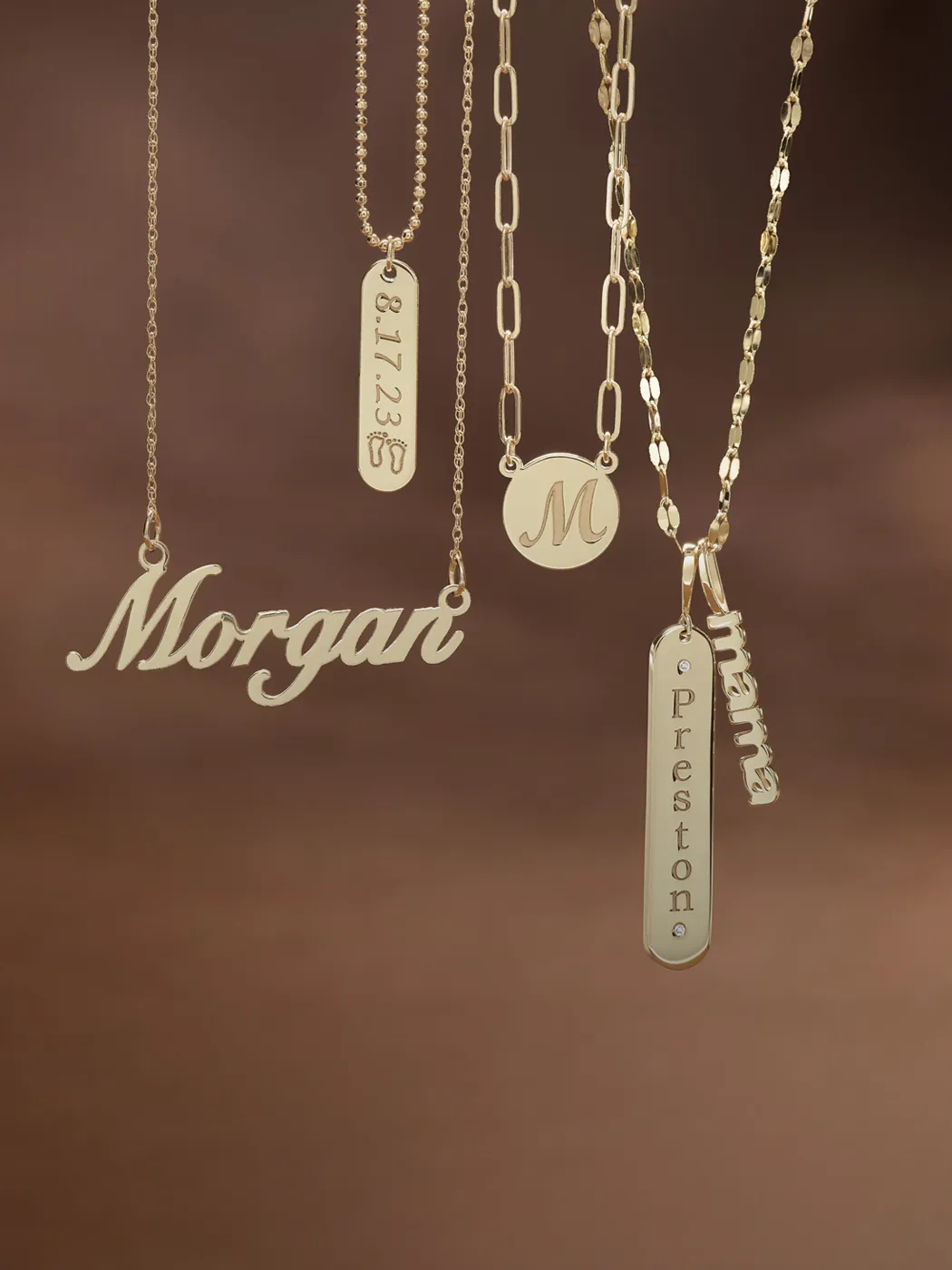 Gold necklaces with personalized name and date pendants on a brown background.