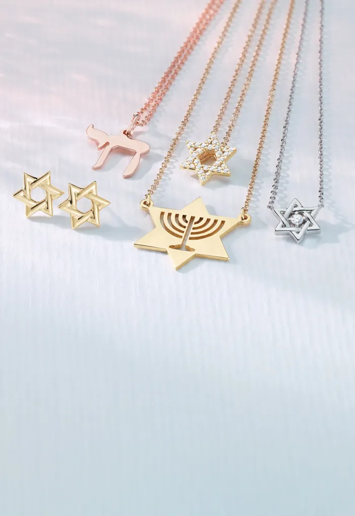 Jewelry featuring Star of David and menorah pendants on chains.