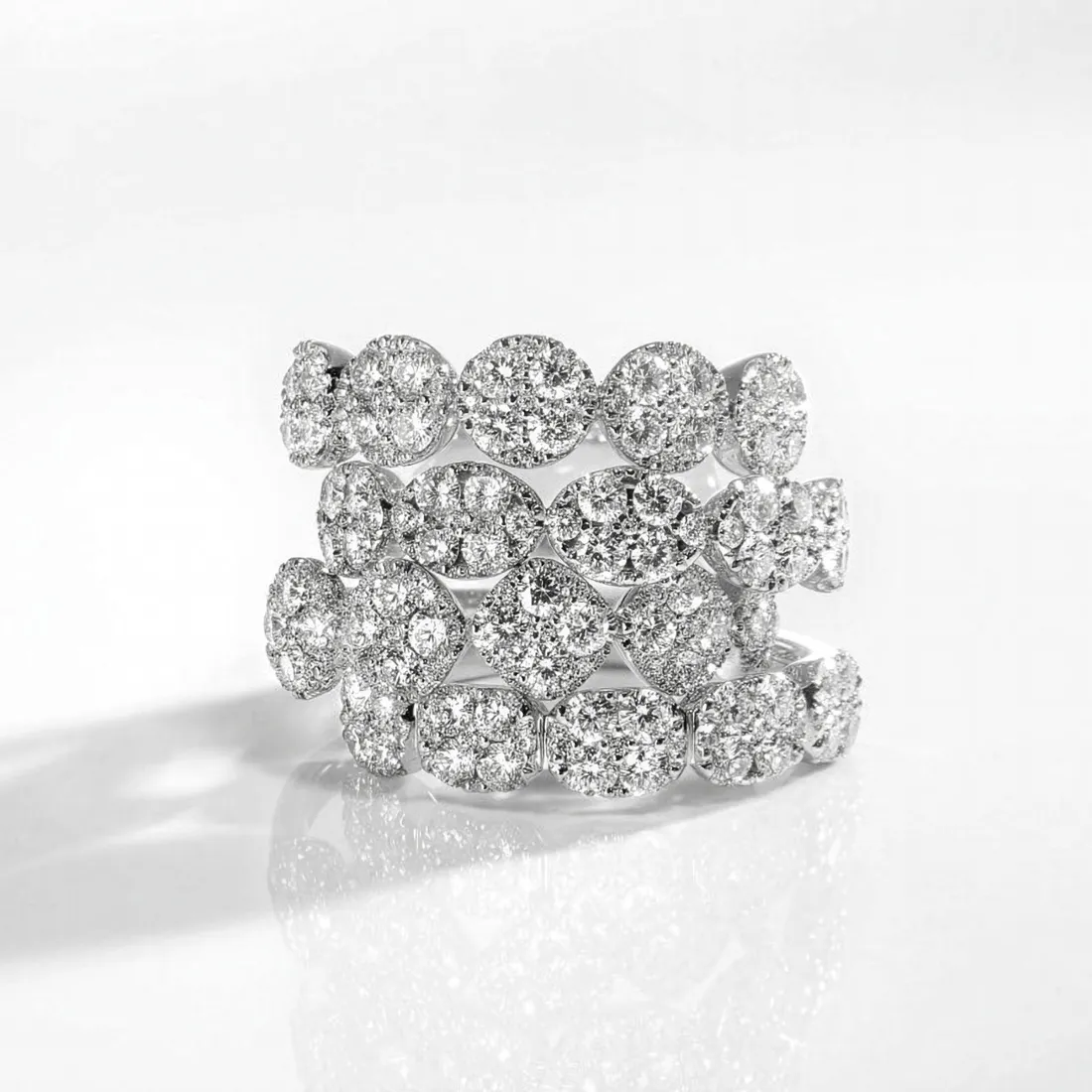 Three stacked diamond rings with various shapes, sparkling on a white background. Visit J.A. Jewelers & Co. for more.