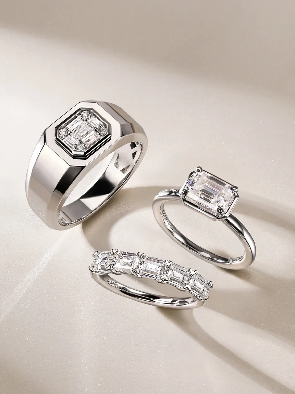 Three elegant rings featuring emerald-cut diamonds, showcasing a modern design in silver. Shop at J.A. Jewelers & Co.