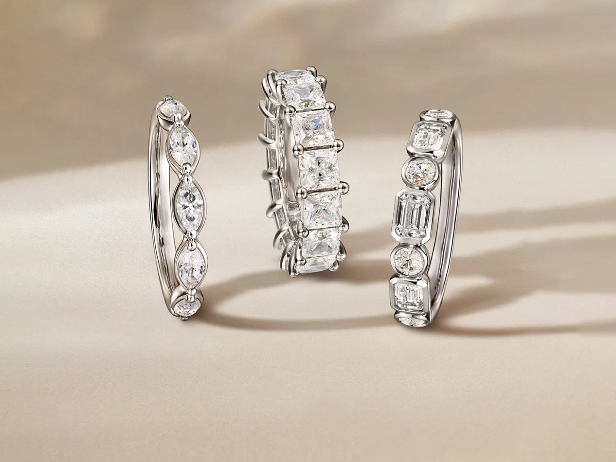 Three elegant diamond rings displayed on a soft background, showcasing various styles and settings. Visit J.A. Jewelers & Co.