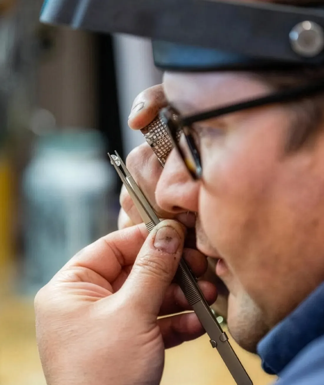 Jeweler closely examining a piece with precision tools at J.A. Jewelers & Company, Farmington.