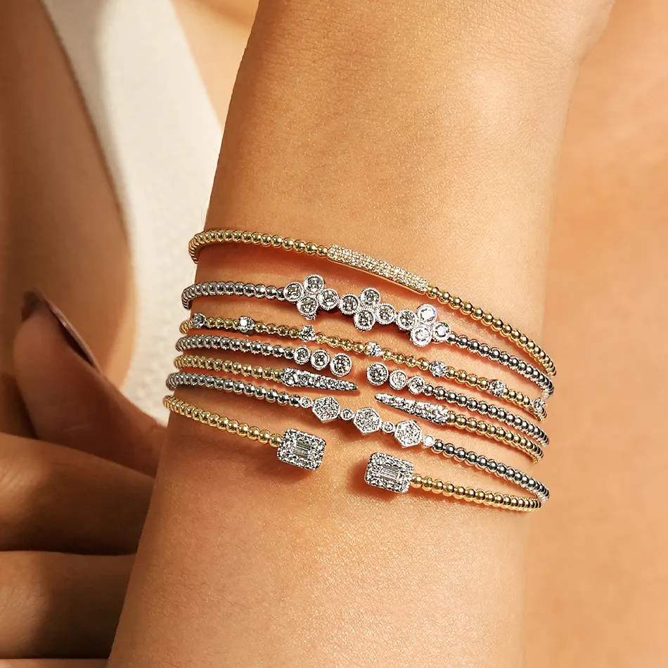 Elegant stacked bracelets featuring gold and silver tones with sparkling diamonds, perfect for any occasion.