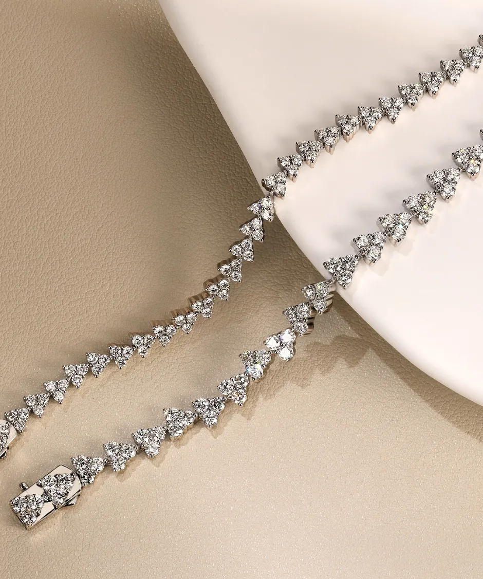 Elegant diamond necklace with triangular designs, displayed on a soft surface. Visit J.A. Jewelers & Co. for more.