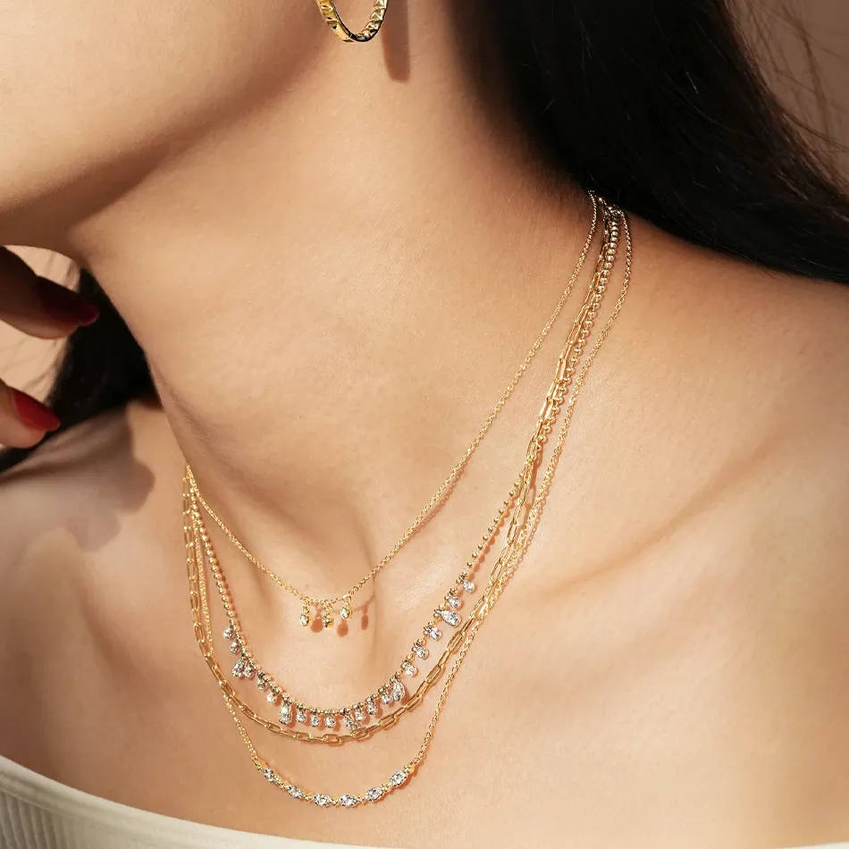 Gold layered necklaces with sparkling accents worn by a model, showcasing elegant jewelry from J.A. Jewelers & Company, Inc.