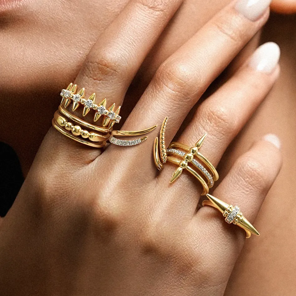 Stylish gold rings with spikes and diamonds on a hand, showcasing J.A. Jewelers' unique jewelry collection.