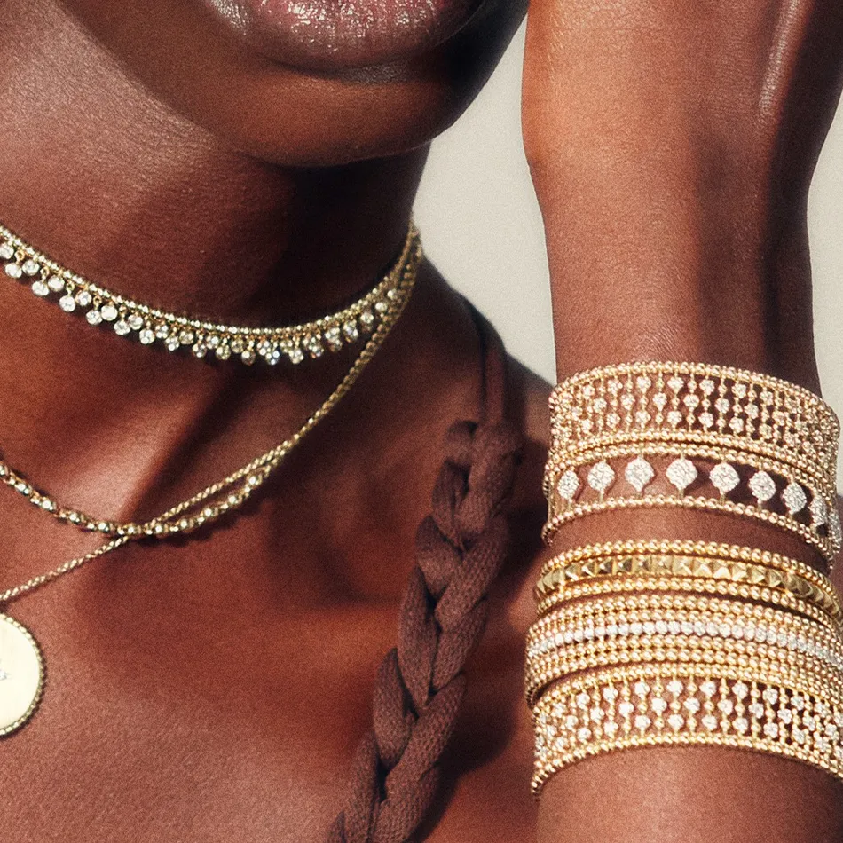 Elegant gold and diamond bracelets worn on a model's wrist, showcasing luxury jewelry from J.A. Jewelers. Shop now!