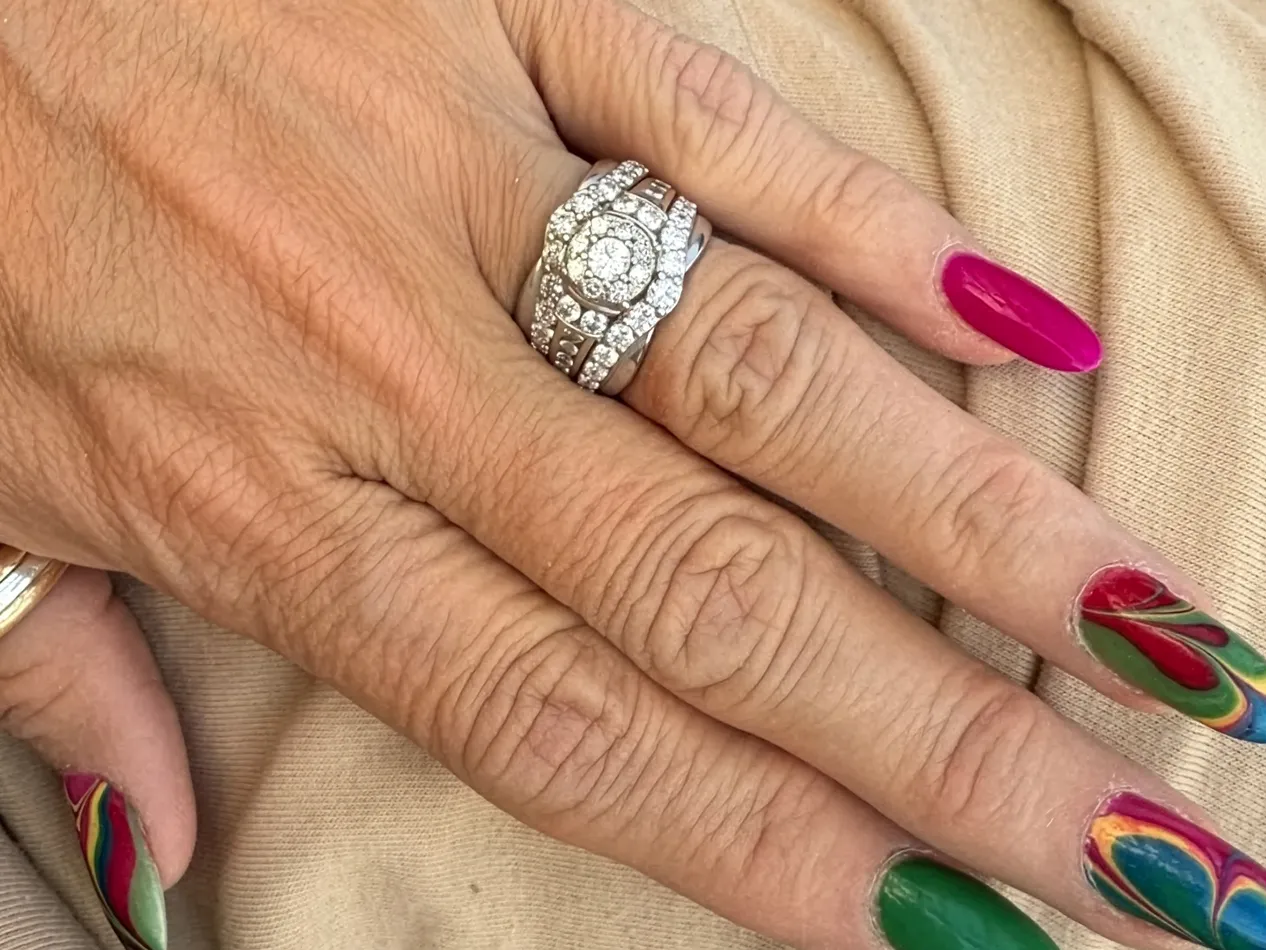 Hand with colorful nail art and a sparkling diamond ring, showcasing jewelry from J.A. Jewelers in Farmington.