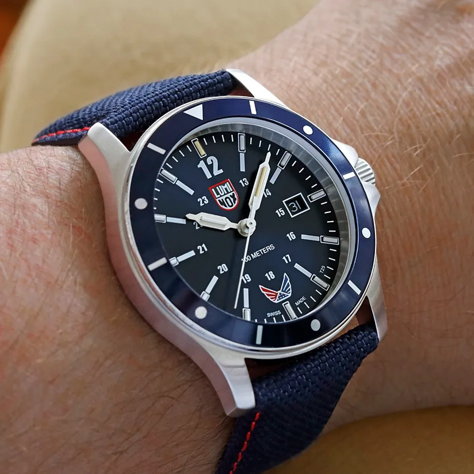 Close-up of a Luminox watch on a wrist, featuring a black dial and navy strap. Shop watches at J.A. Jewelers & Company, Inc.