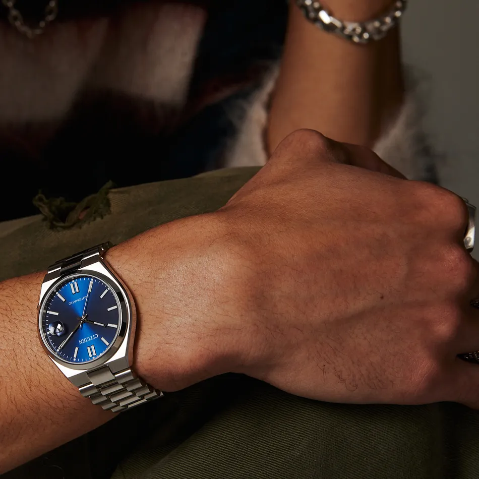 Close-up of a Citizen watch with a blue dial on a person's wrist, showcasing style and elegance.