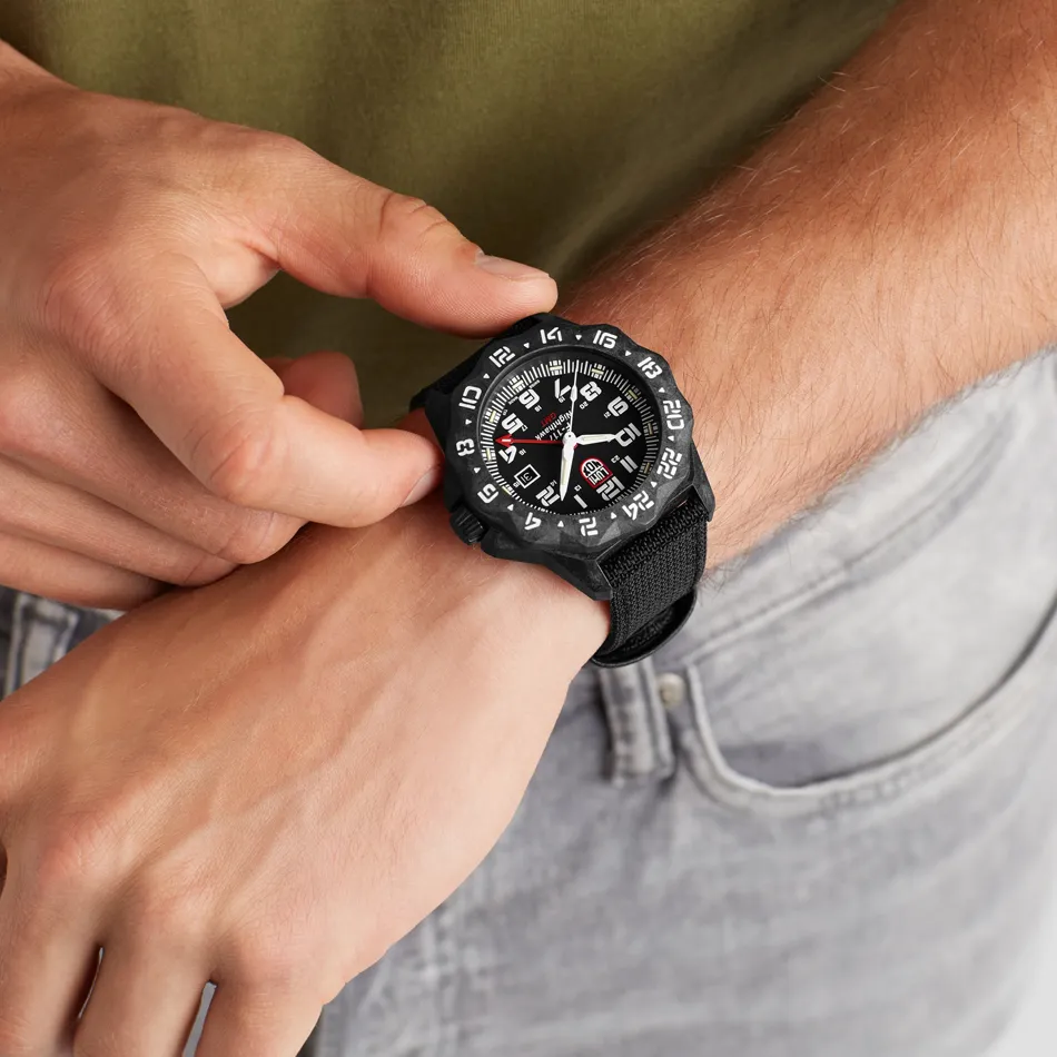 A person adjusting a black Luminox watch on their wrist, showcasing its bold design and features.