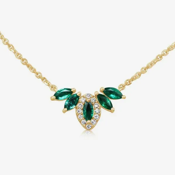 Gold necklace with green gemstones and diamond accents on a chain.