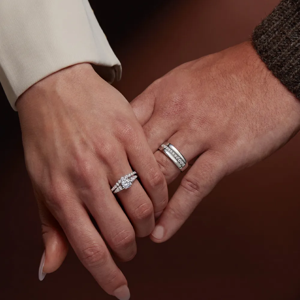 Couple's hands with engagement and wedding rings, symbolizing love and commitment. Visit J. Anthony Jewelers in Neenah.