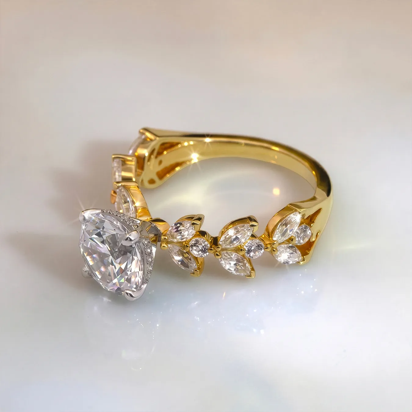 Gold ring with large oval diamond and marquise accents on a reflective surface.