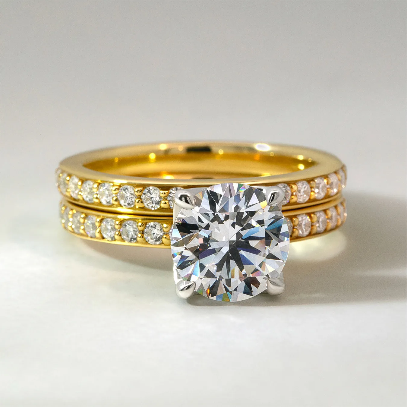 Two gold rings with diamonds, one featuring a large round diamond solitaire.