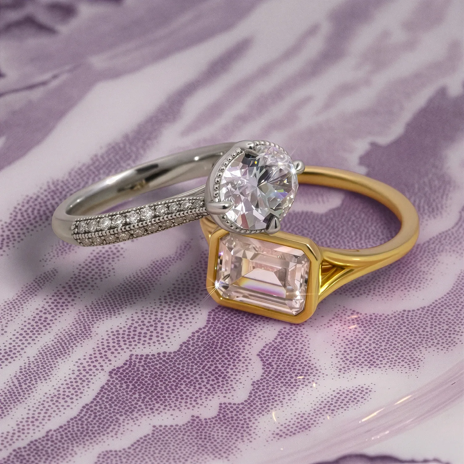Two elegant rings: a silver band with a round diamond and a gold band with an emerald-cut stone on a purple background.