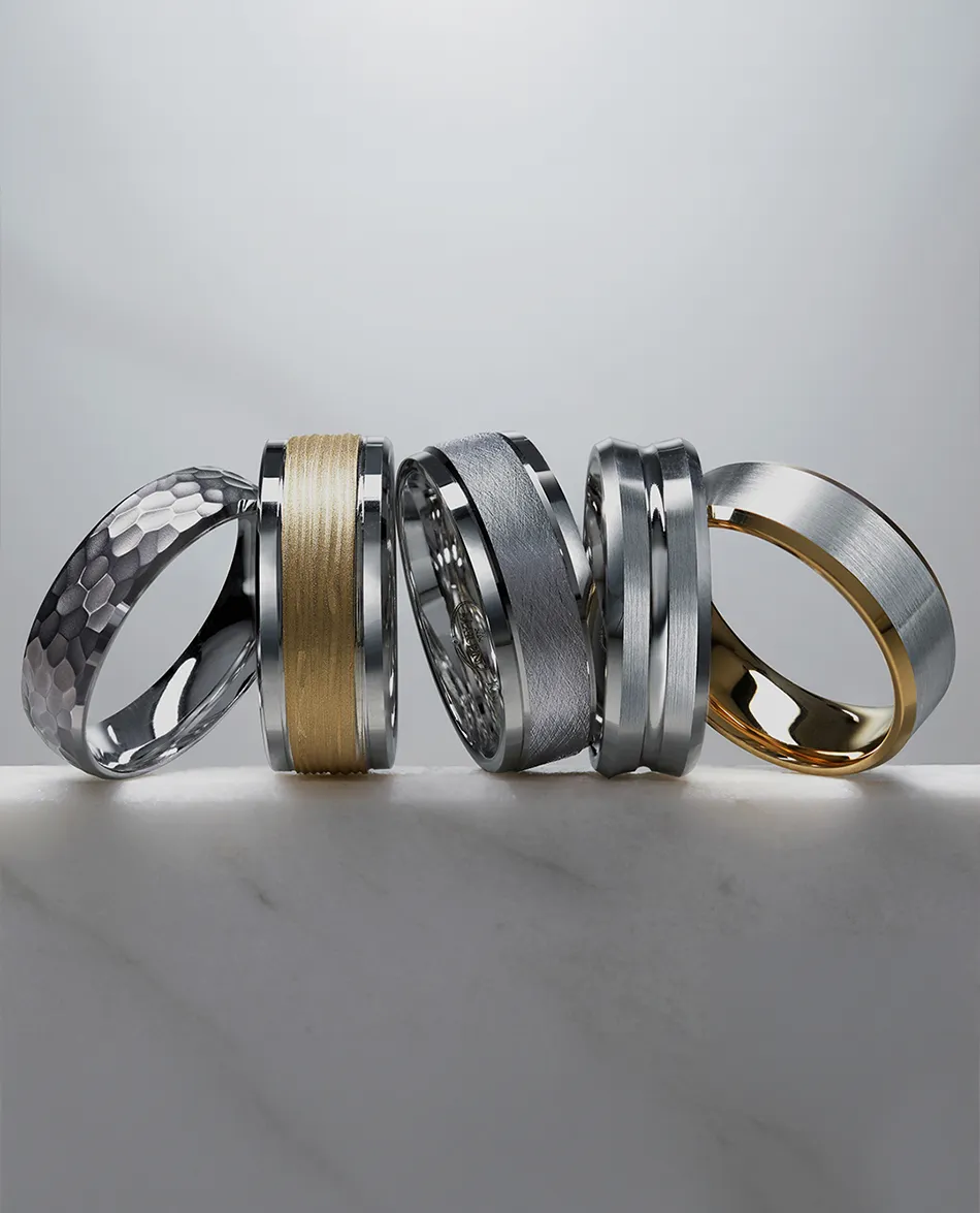 Men's rings with varied textures and finishes on display. Shop Men's Bands.