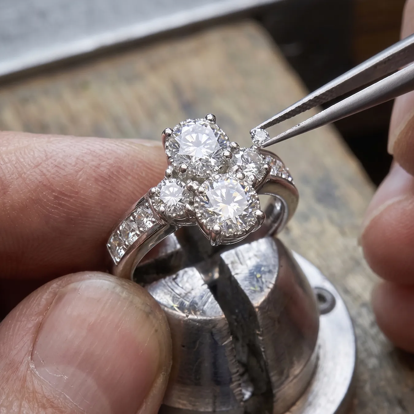 Jeweler setting a diamond on a ring with tweezers at Jayson Jewelers.