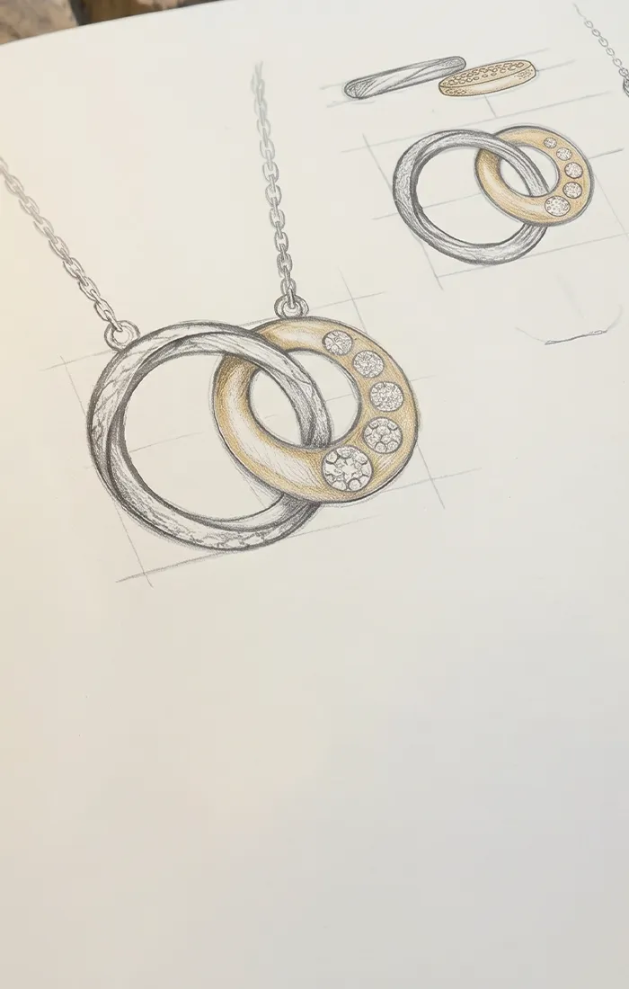 Jewelry design sketchbook with a pencil drawing of a necklace.