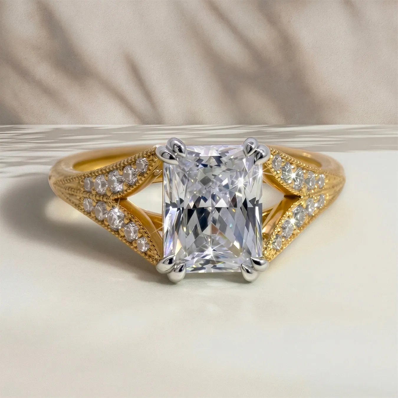 Elegant gold ring with a large rectangular diamond and smaller side stones on a textured band.