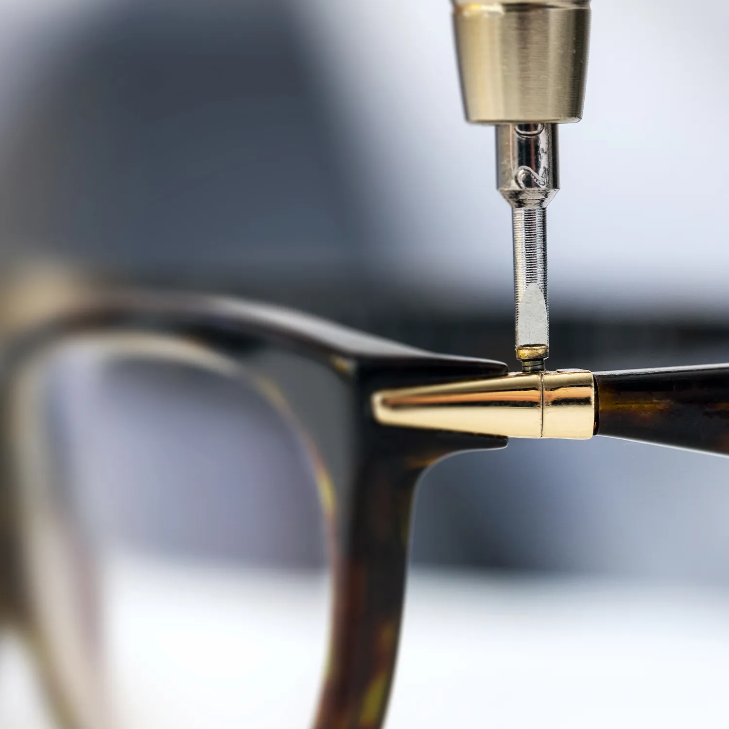 Jeweler adjusting a gemstone ring with tools on a workbench.