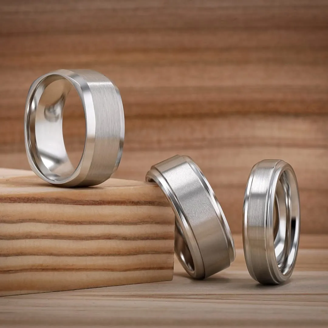 Two elegant gold rings, one smooth and the other textured, displayed on a marble surface.