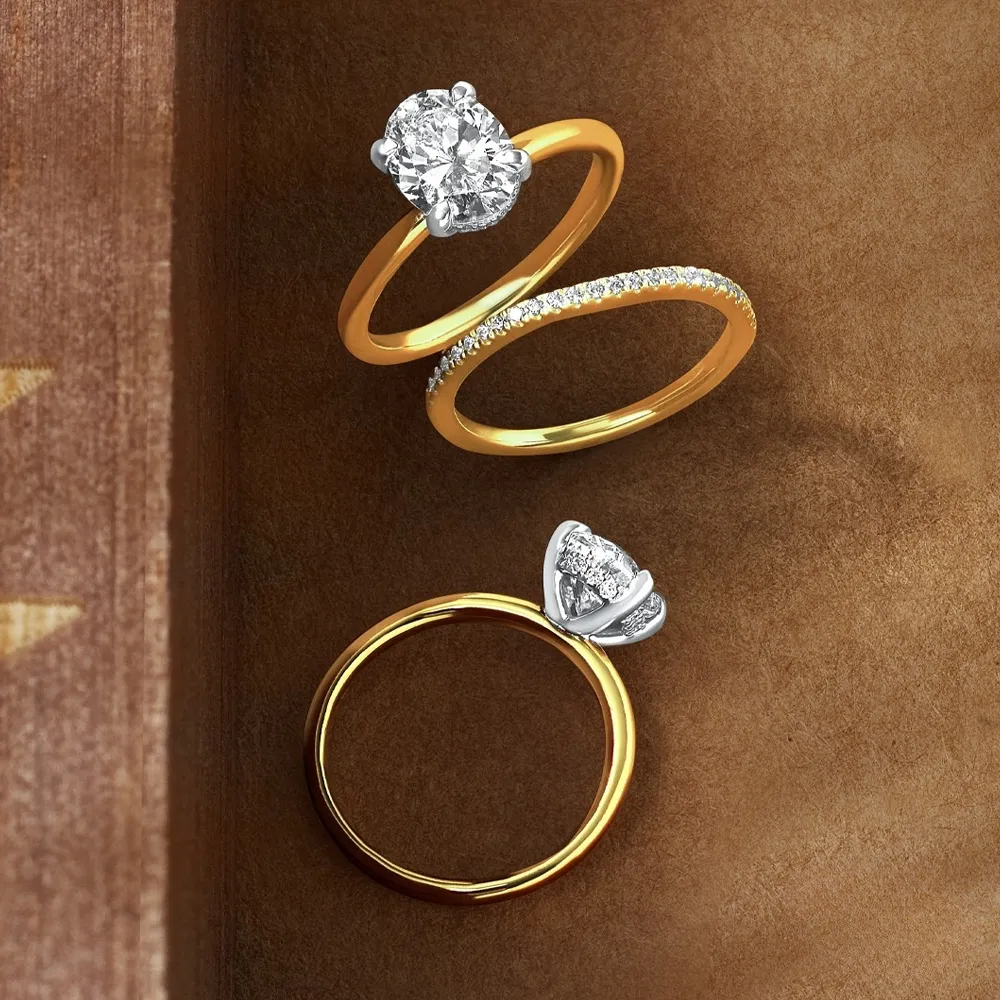 A hand wearing a diamond engagement ring holds pink tulips, showcasing fine jewelry.