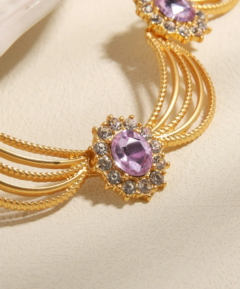 Elegant gold necklace with purple gemstones and sparkling accents, perfect for special occasions.