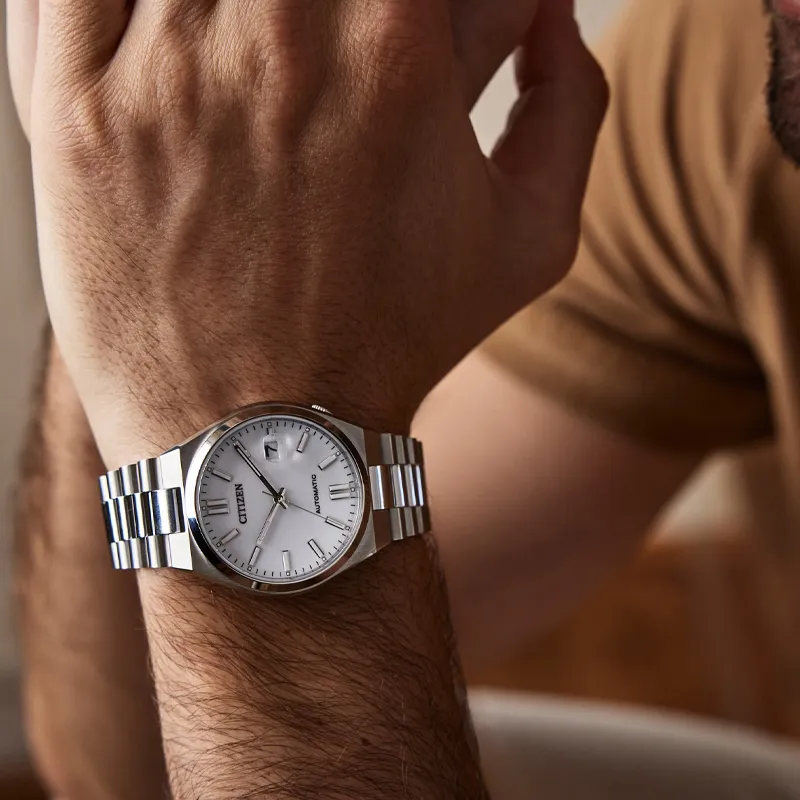 Close-up of a man's wrist wearing a Citizen watch with a silver band and white face.
