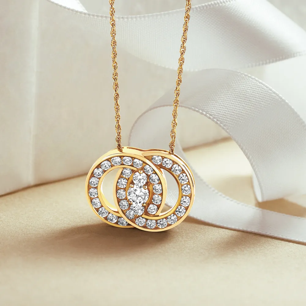 Three elegant diamond rings with gold bands displayed on a soft fabric background.