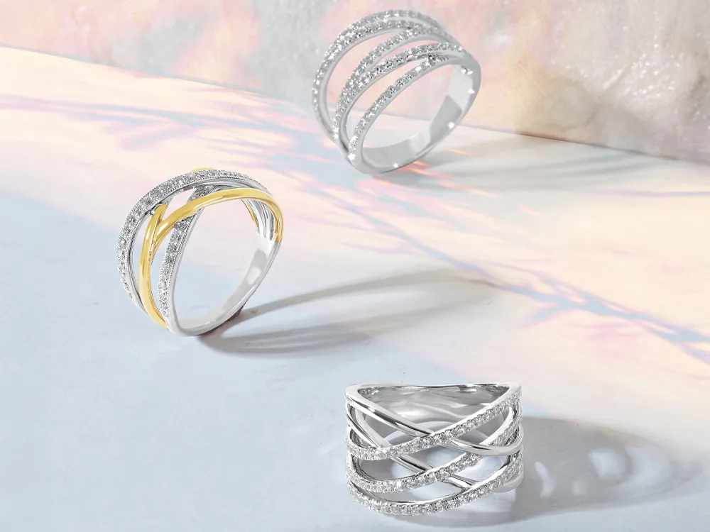 Two elegant gold engagement rings featuring marquise-cut diamonds and intricate designs, displayed on a light background.