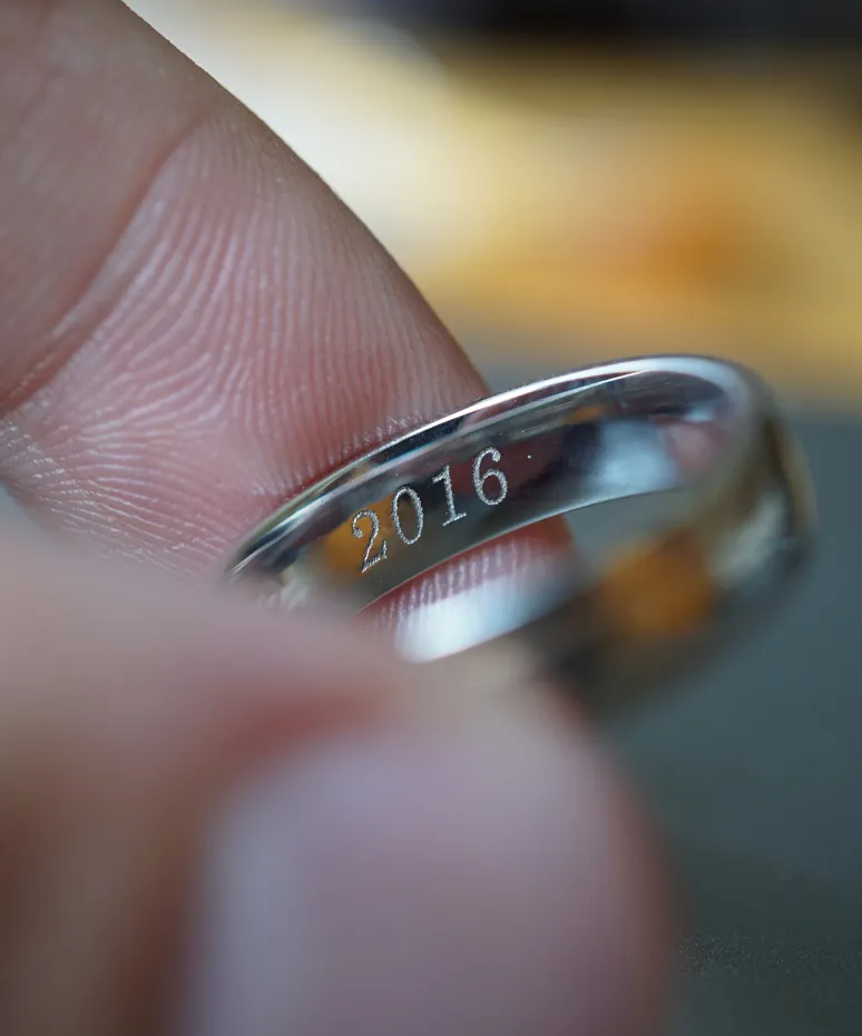 Close-up of a silver ring engraved with 