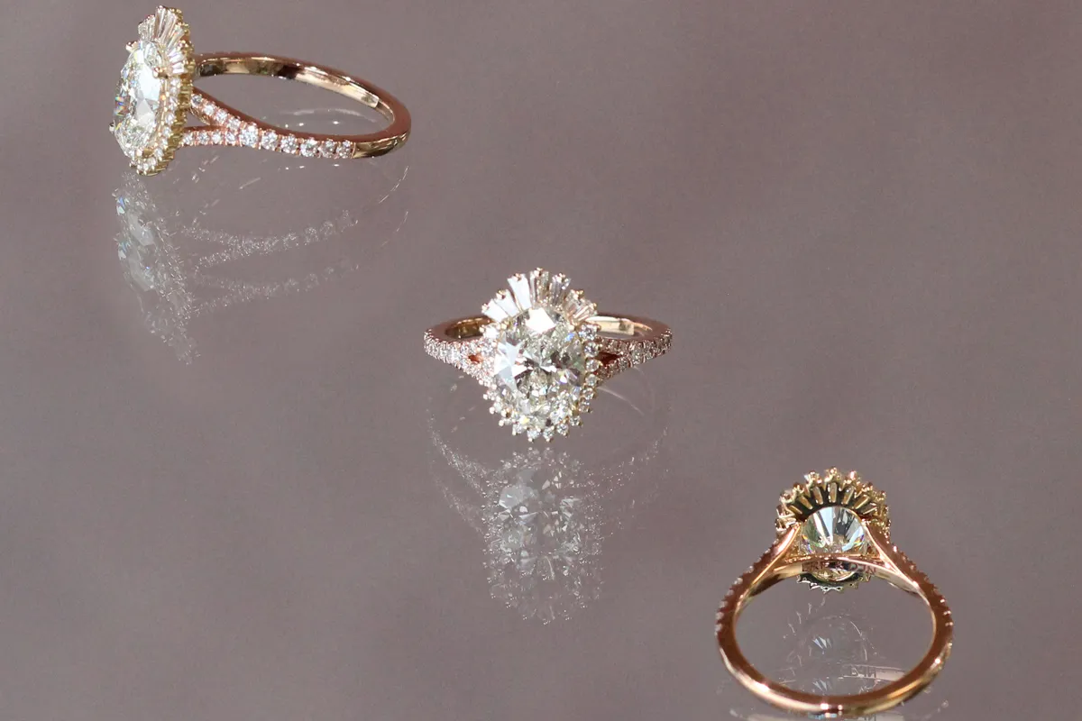 Engagement Ring being placed on ring finger with solitaire diamond. Find engagement rings at The Jewelry Source El Segundo, CA