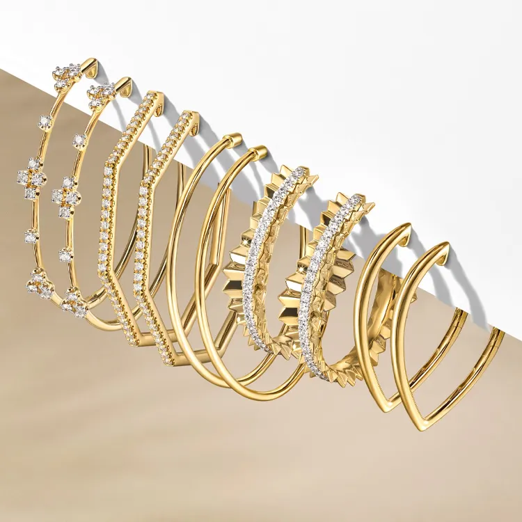 Gold and diamond earrings displayed elegantly, showcasing various styles. Shop at Jim Kryshak Jewelers in Wausau.