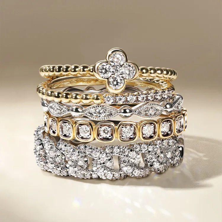 Stack of elegant gold and silver rings with diamond accents, available at Jim Kryshak Jewelers. Click to explore more.
