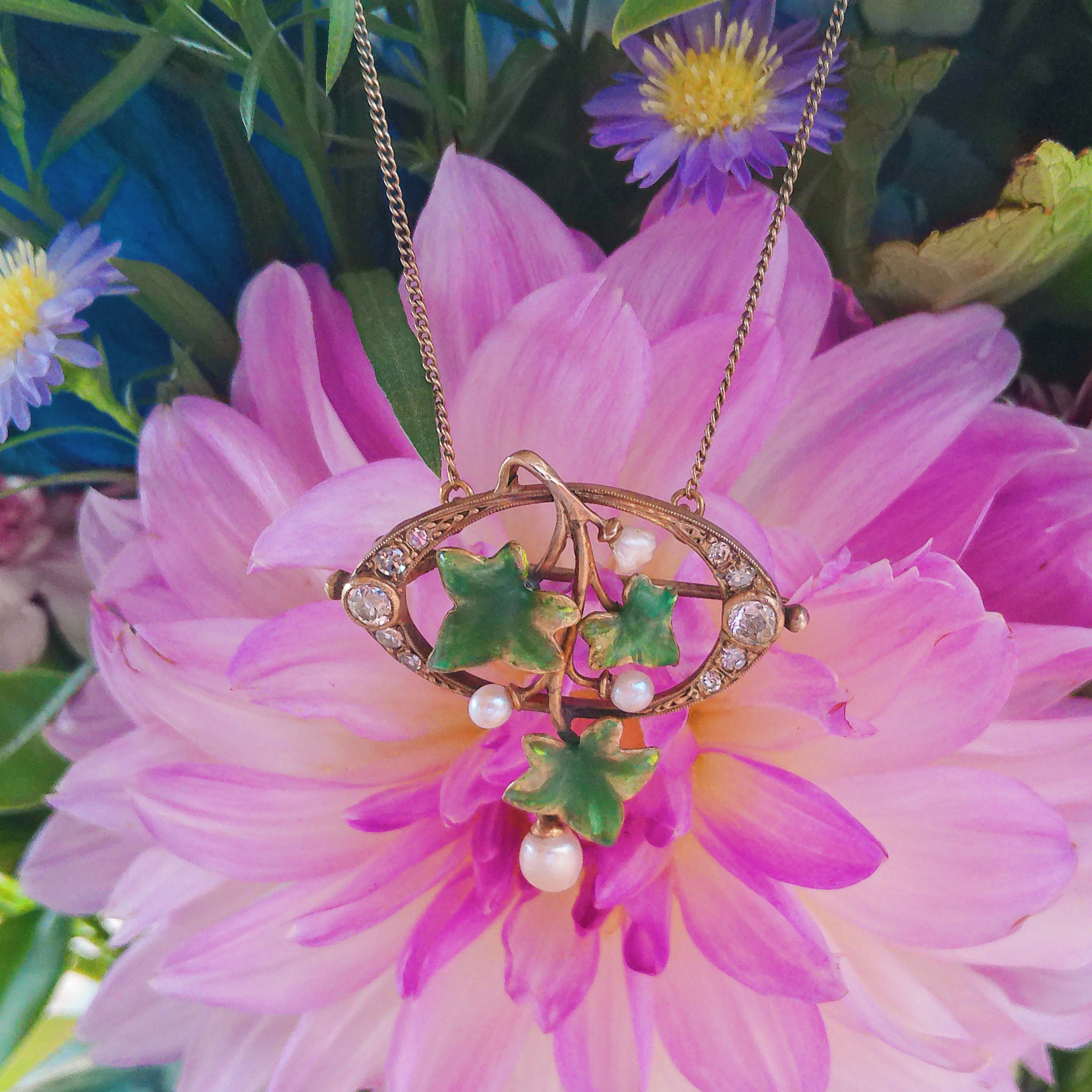 Vintage gold necklace with green leaves and pearls, set against a pink flower background. Click to explore more jewelry.