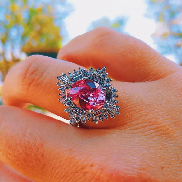 Pink sapphire ring with a baguette diamond halo