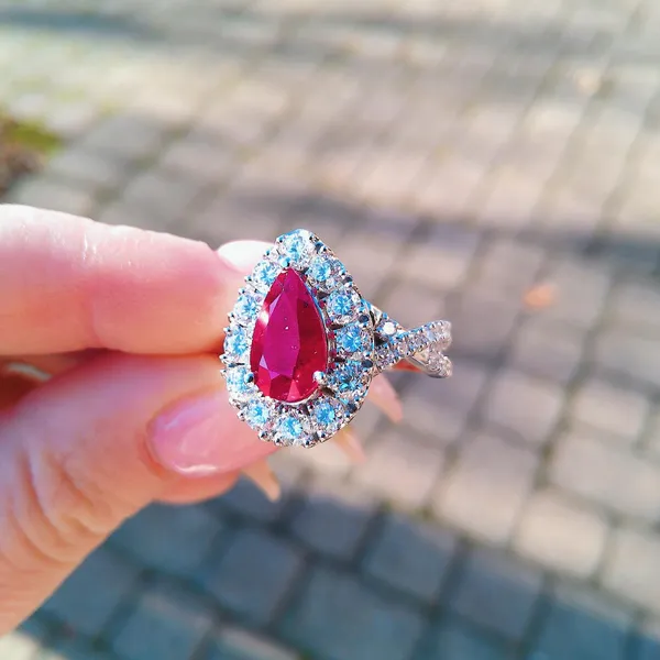 Pear ruby ring with a diamond halo