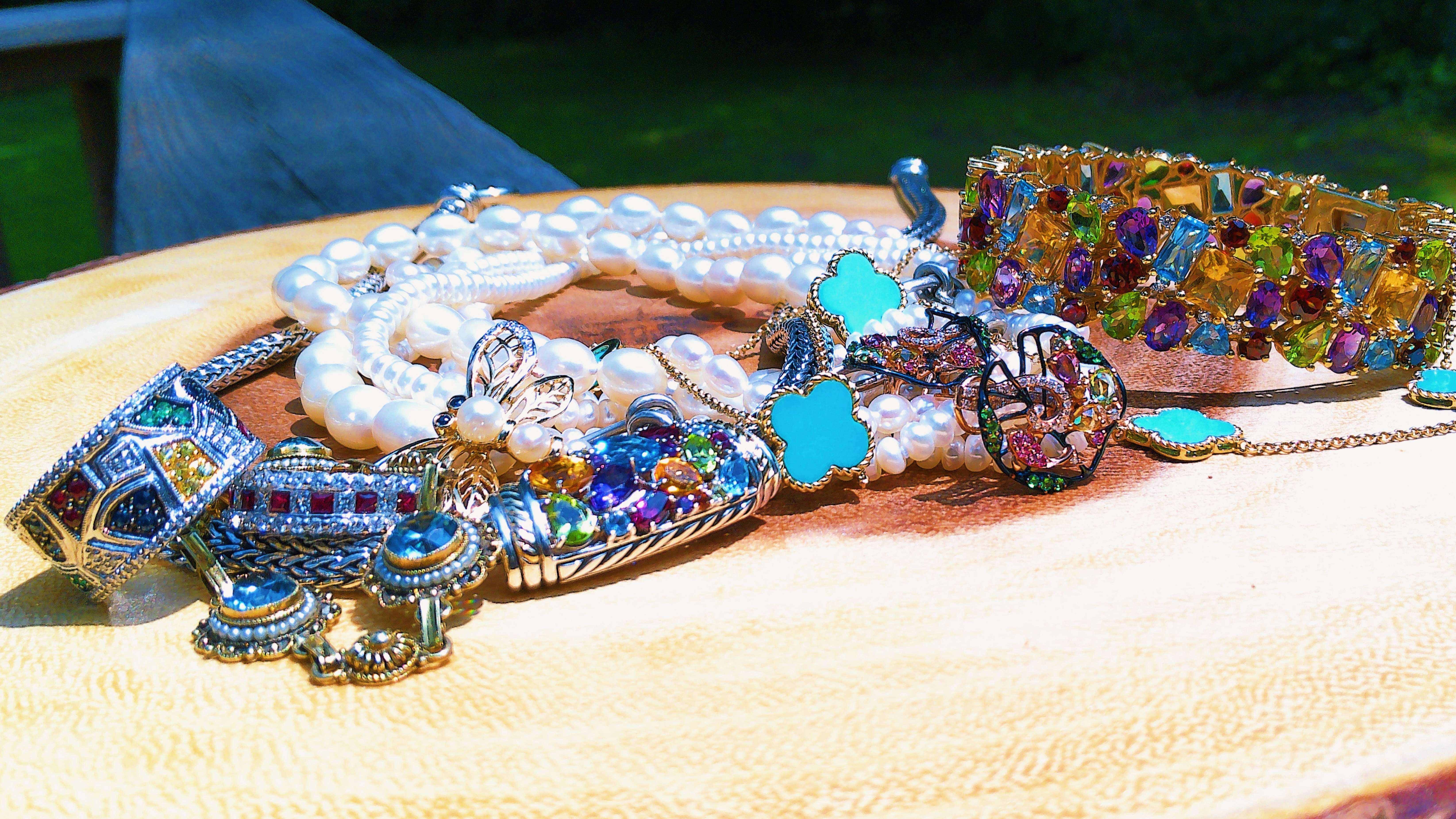 Colorful summer inspired vintage jewelry pieces, including rings, necklaces, and bracelets displayed on a wooden surface.