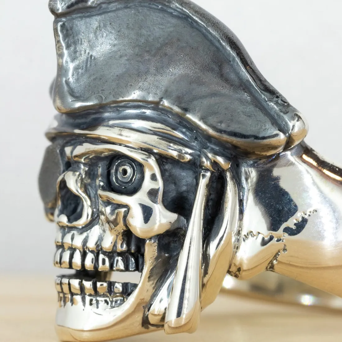 Silver skull ring with pirate hat, detailed design.