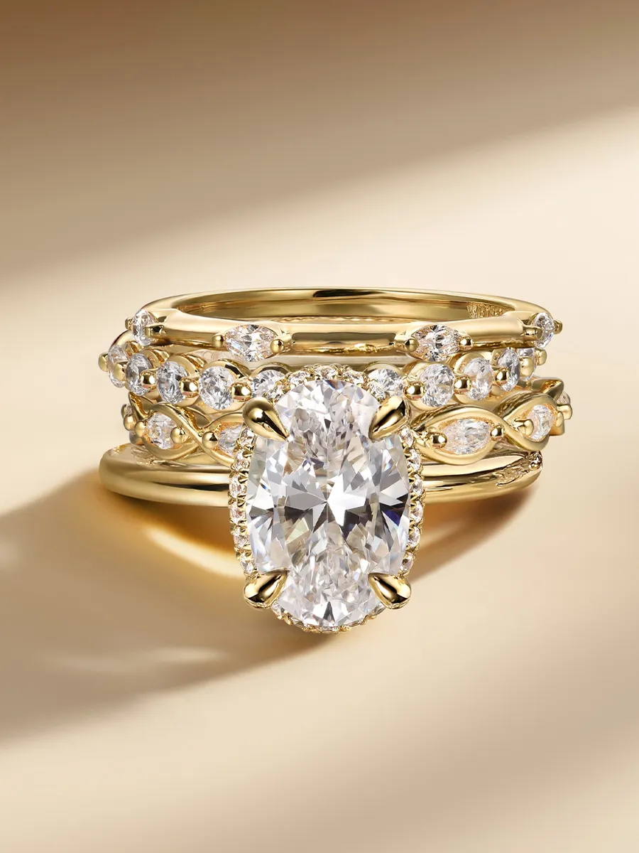 Gold ring set with large oval diamond and smaller diamonds on a beige background.