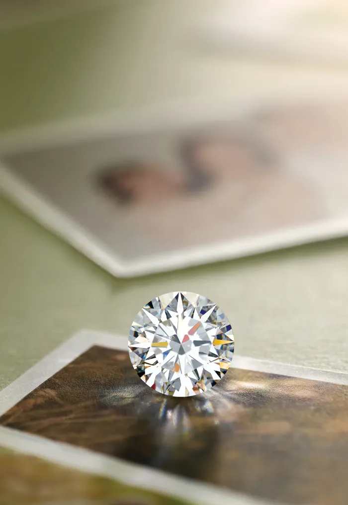 A sparkling diamond rests on photographs against a green background.