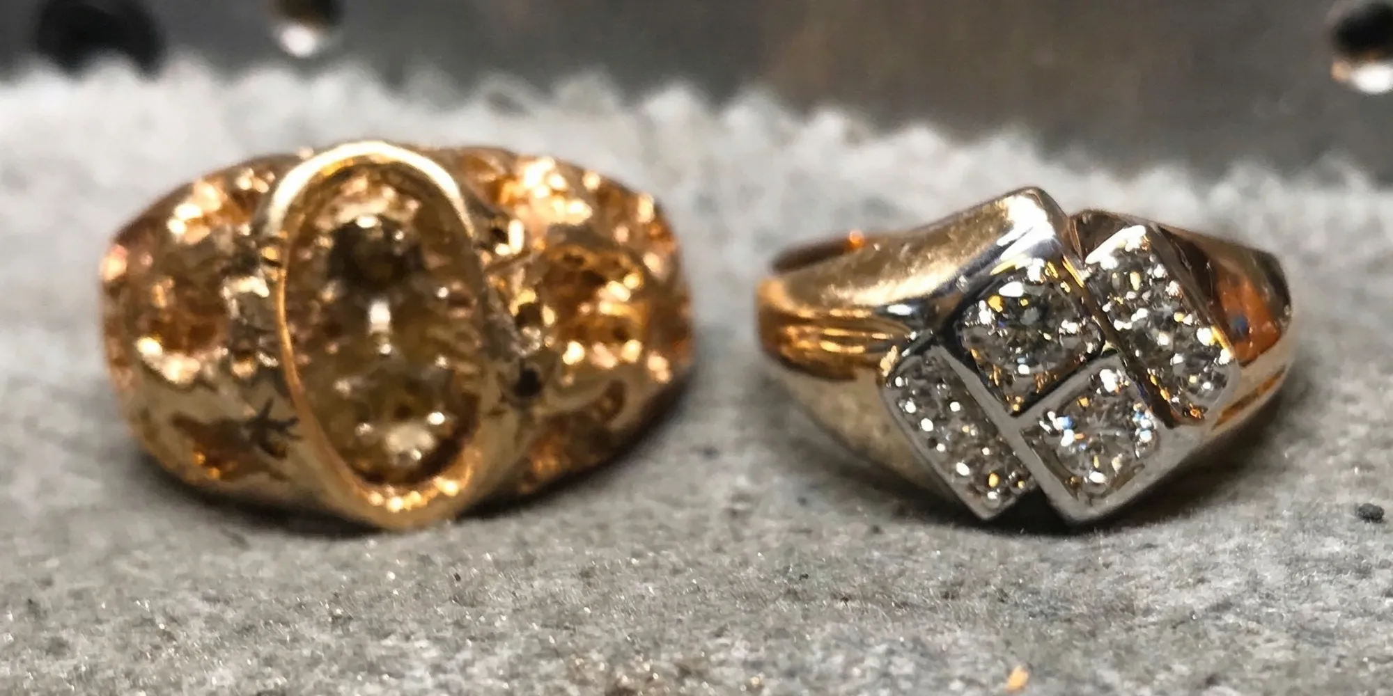 Oval diamond ring with halo and split shank on textured fabric background.