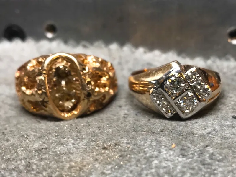 Oval diamond ring with halo and split shank on textured fabric background.