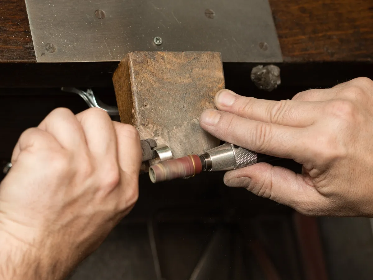 Jeweler polishing metal ring band