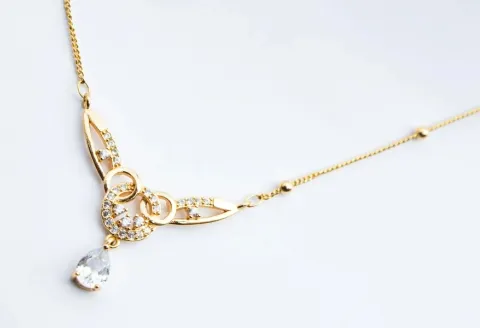 Gold necklace with teardrop diamond pendant detail