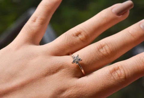 Elegant diamond cluster engagement ring on hand.