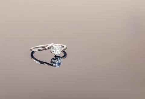Silver engagement ring with diamond reflection.